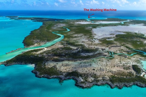 This stunning aerial photo shows Shroud Cay in the Bahamas, beautifully capturing its diverse landscape and vibrant turquoise waters. The image highlights the intricate network of mangroves and the meandering channels that snake through the cay, which are typical of this area. These channels are shallow enough to explore by kayak or paddleboard, allowing visitors to navigate through the serene natural environment closely. The surrounding waters, famous for their clarity and richness in marine life, offer fantastic opportunities for snorkeling. This secluded area is a perfect example of the unspoiled beauty of the Exumas, providing a peaceful escape in a natural setting.