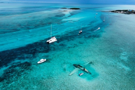 Boats Anchored Around a Plane Wreck at Norman's Cay, Bahamas